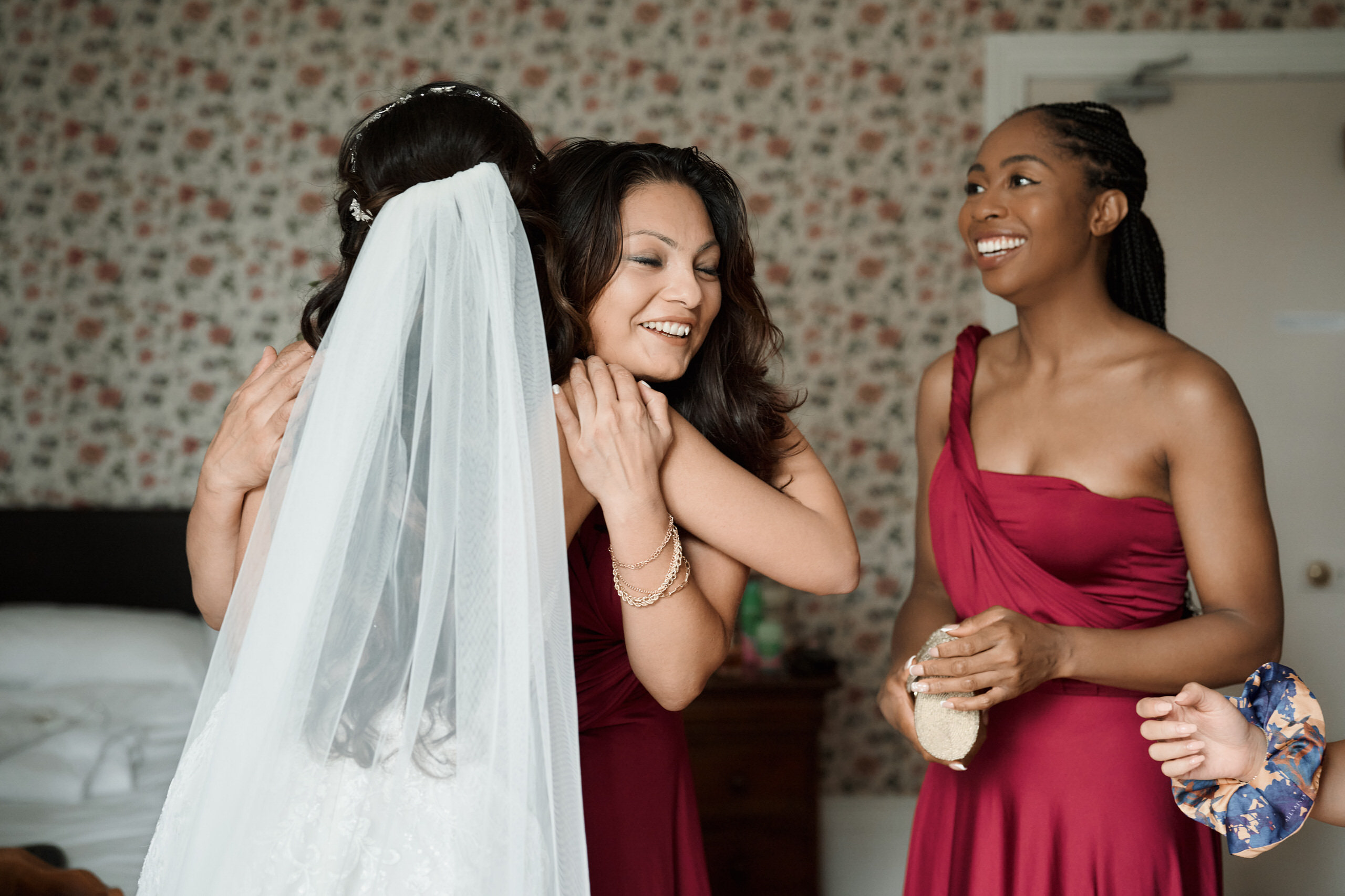 A woman in a red dress is with a bridesmaid.