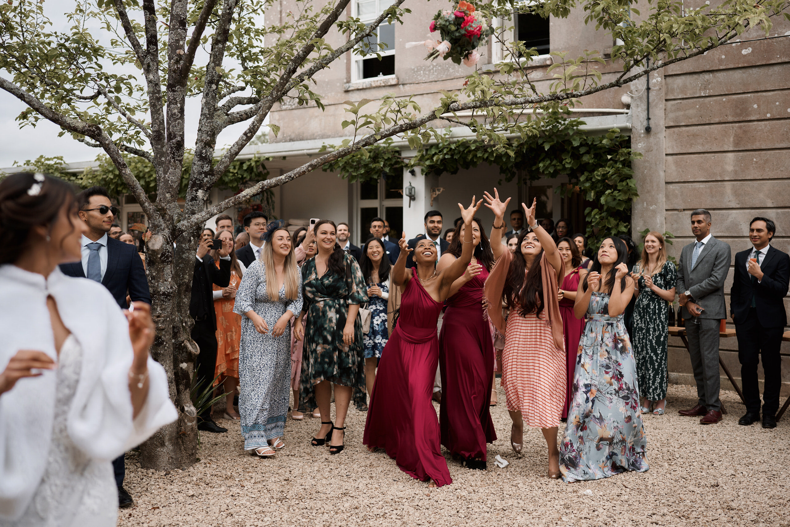 Some bridesmaids are waving their hands in the air at a wedding.