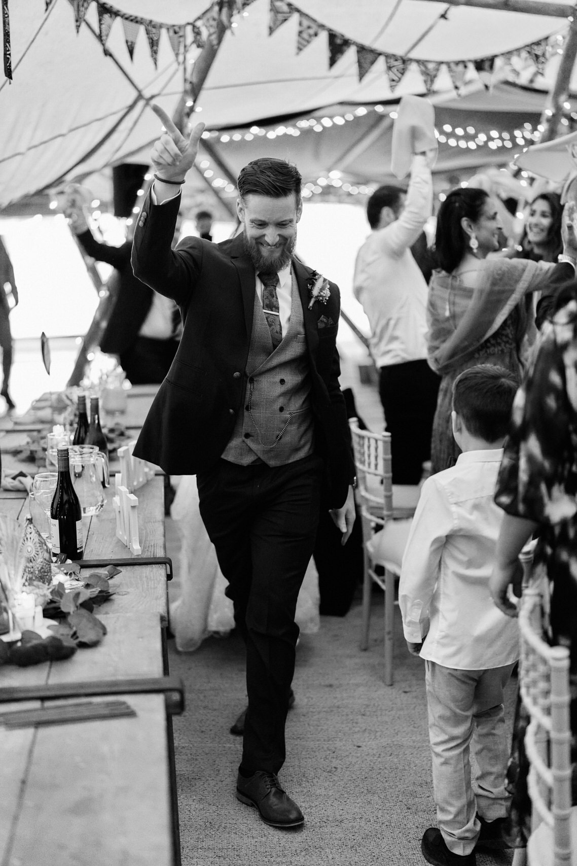 A picture in black and white shows a guy dancing inside a tent.