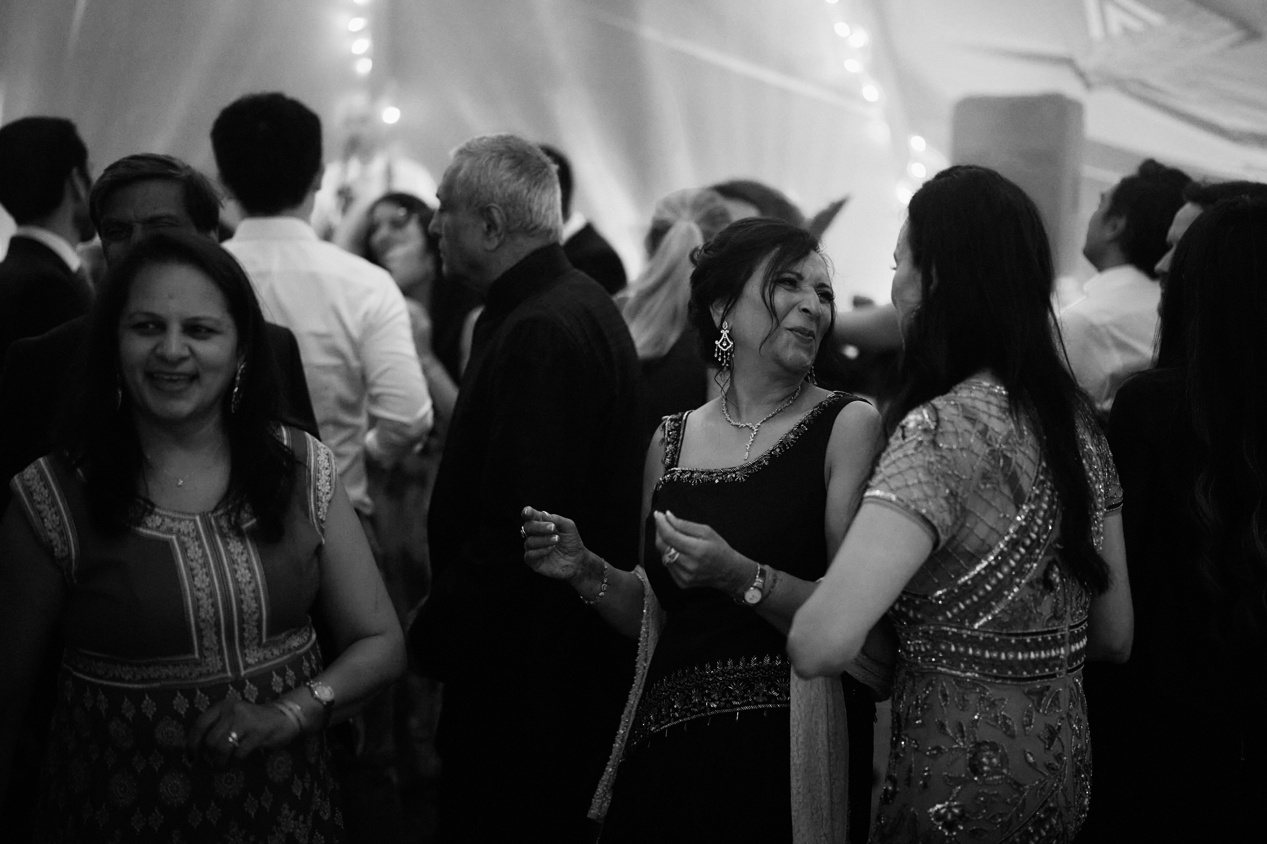 A black and white picture of people dancing at a wedding.