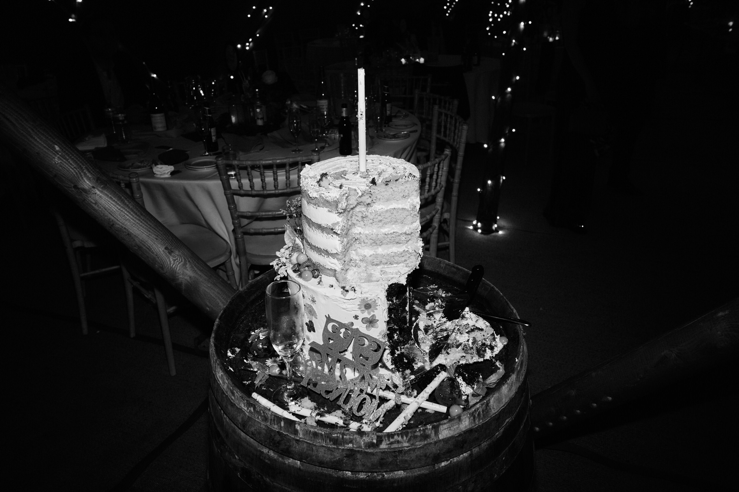 A wedding cake is placed on a barrel.