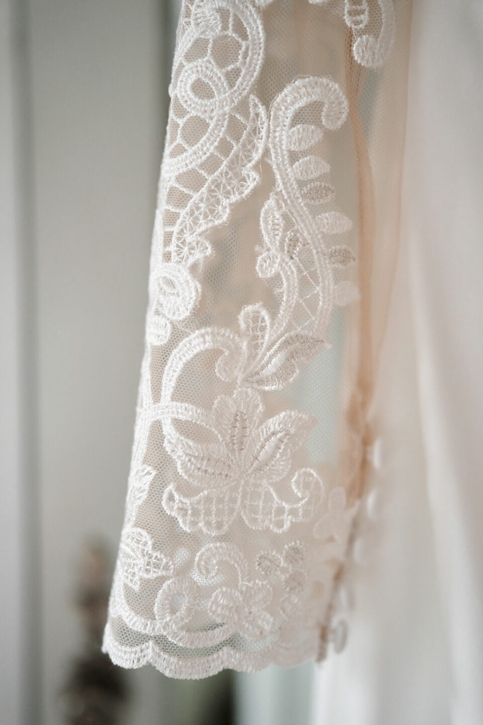 A detailed view of a white lace wedding dress.