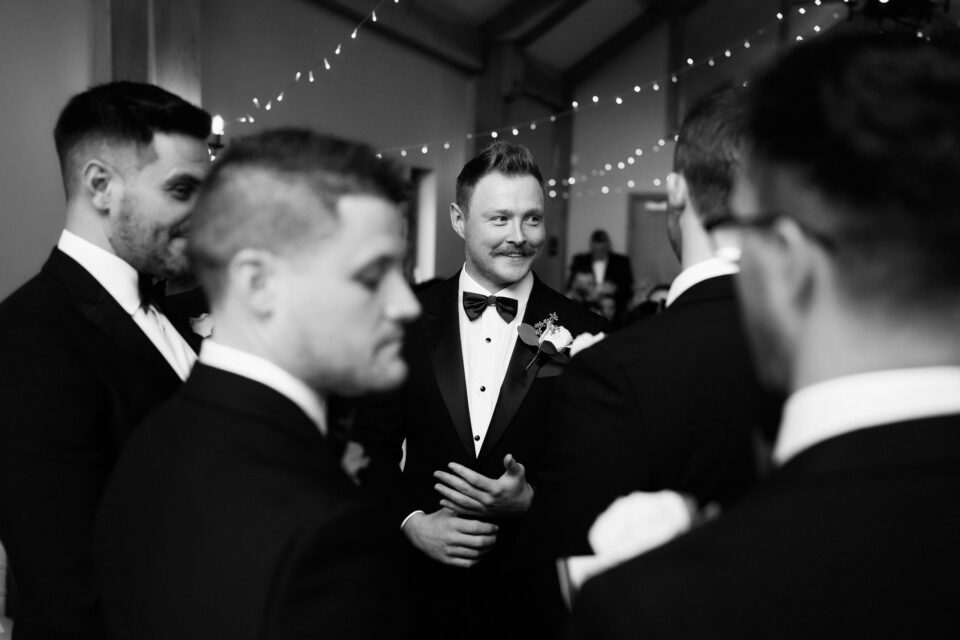 A black and white picture of best men dressed in suits.