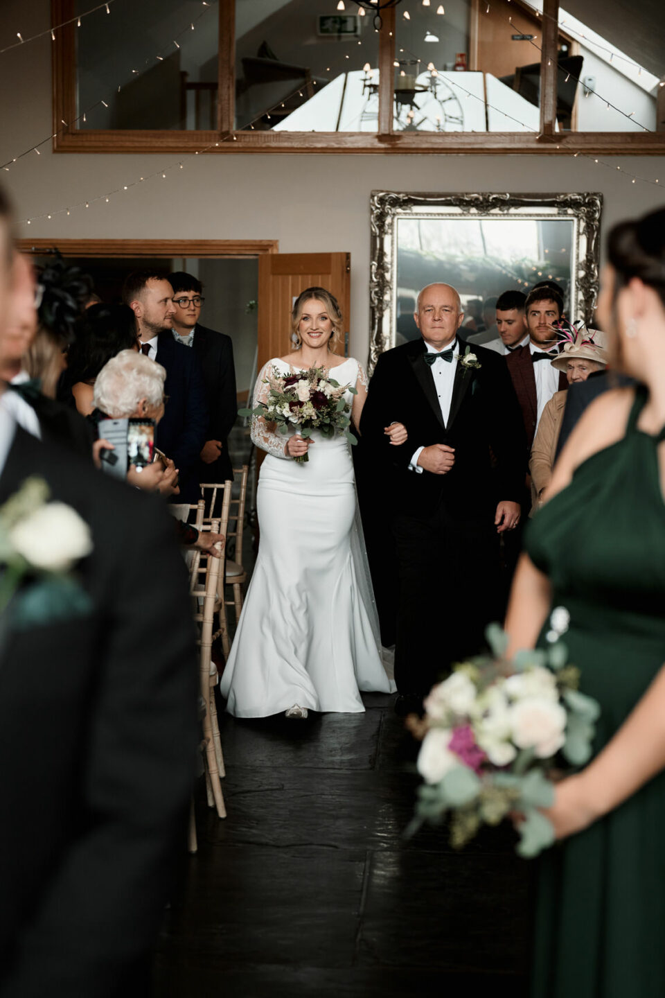 A woman being walked down the wedding aisle by her dad.