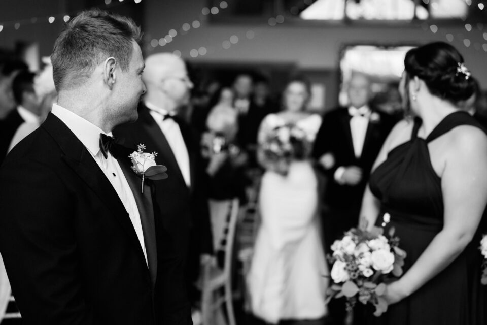 A black and white picture of a bride and groom walking down the wedding aisle.