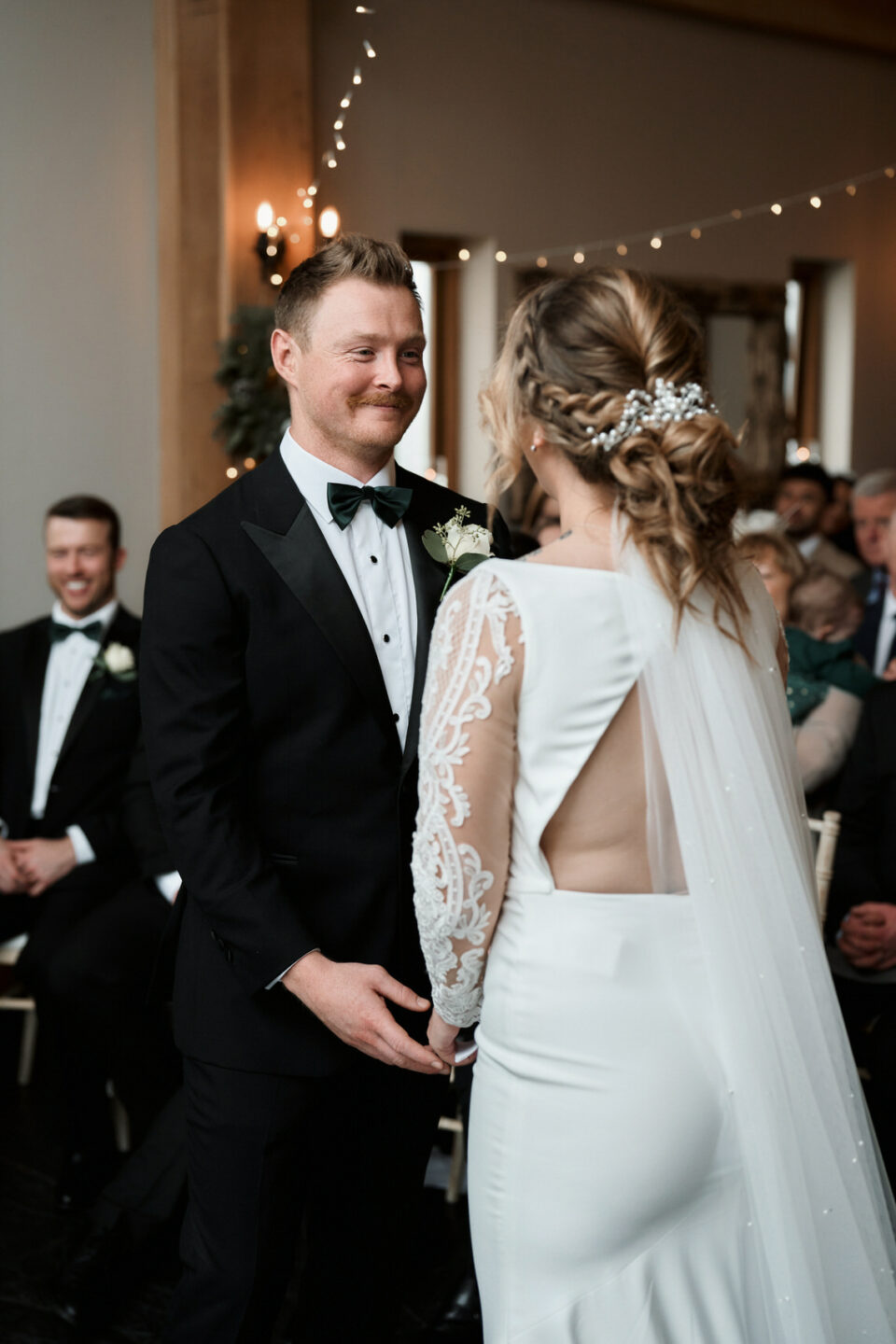 A man and woman grinning at each other while getting married.