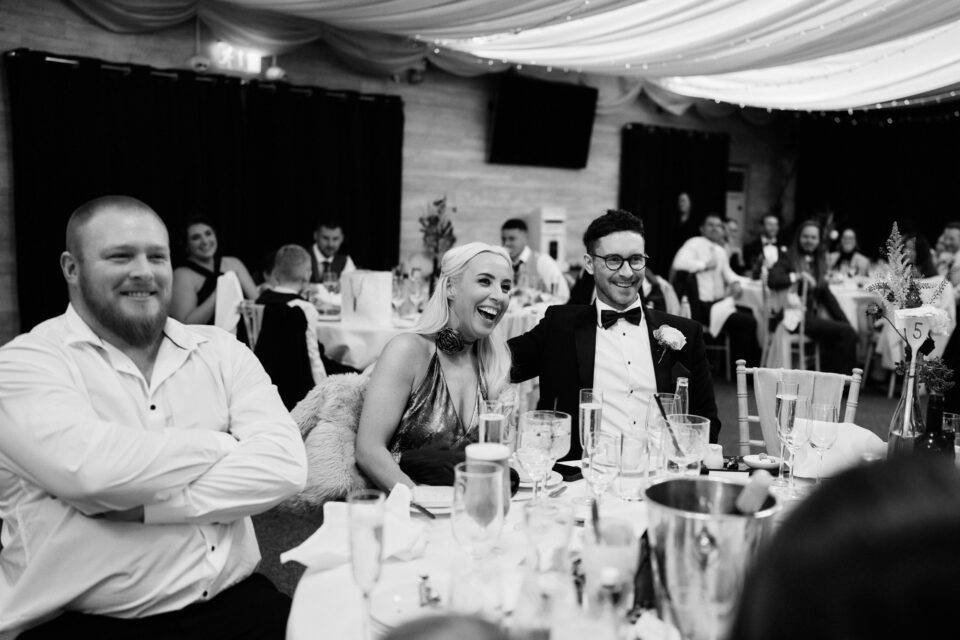 People cracking up at a wedding party.