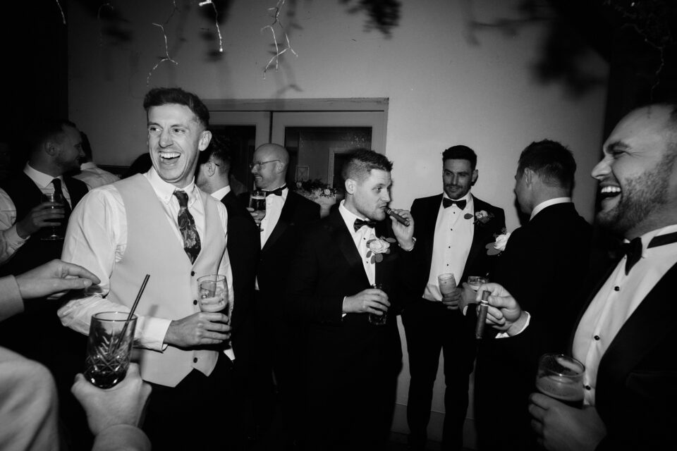A bunch of guys in suits joking around at a party.