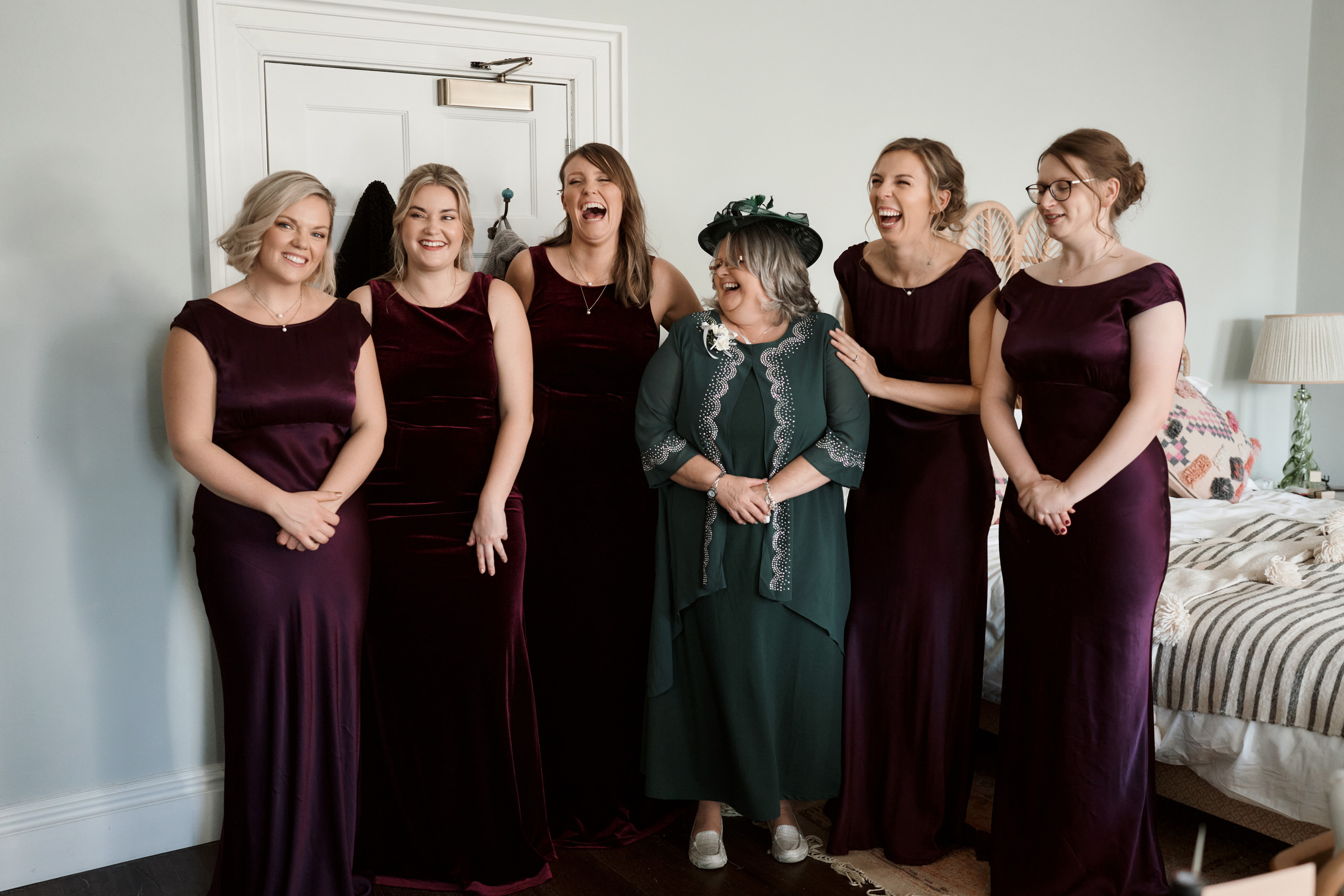 A bunch of bridesmaids wearing dark red dresses.