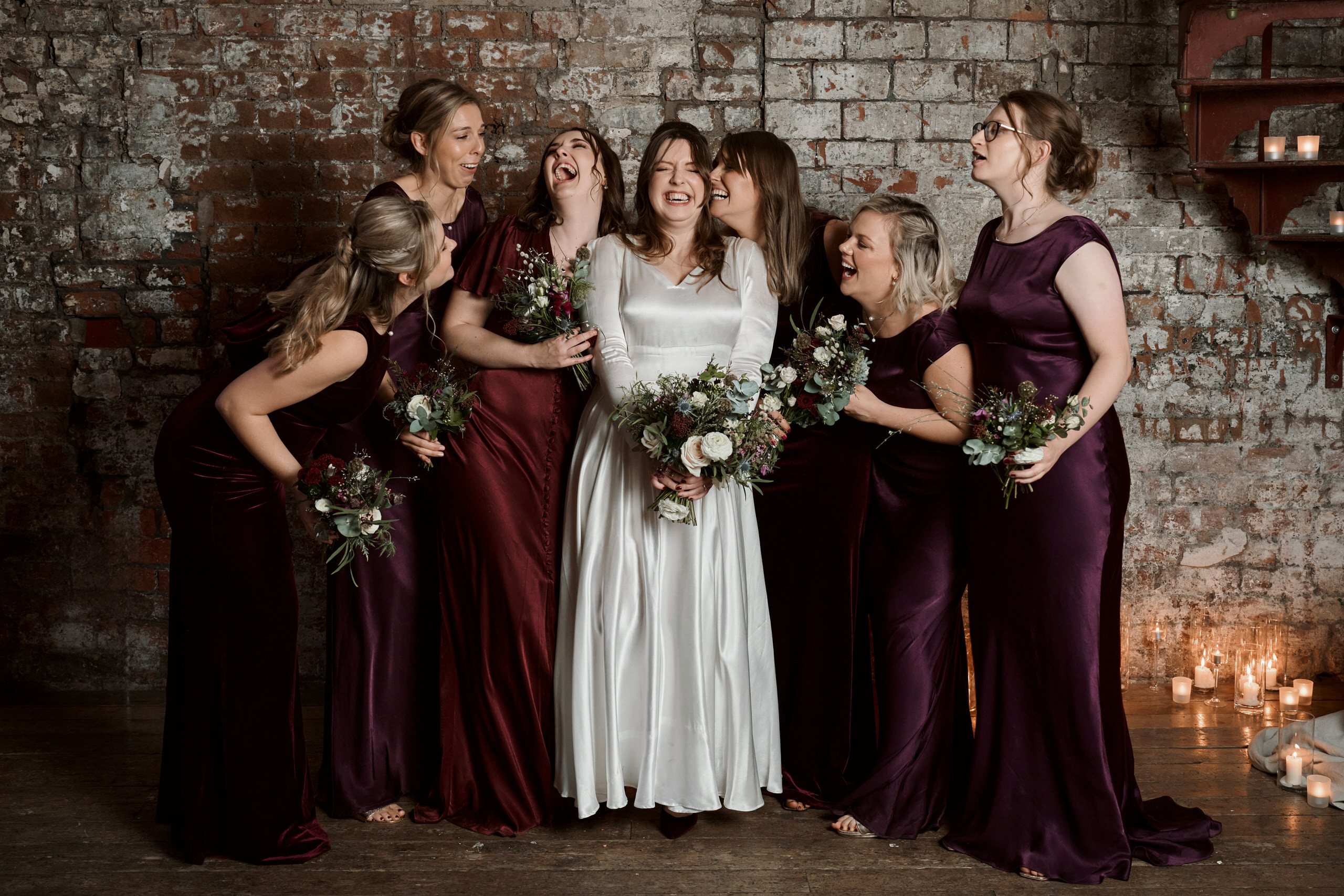 A bride and her bridesmaids are wearing burgundy dresses.