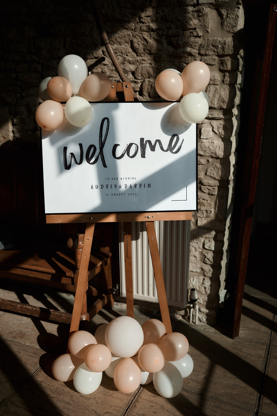 A welcome sign surrounded by balloons is set up on a stand.