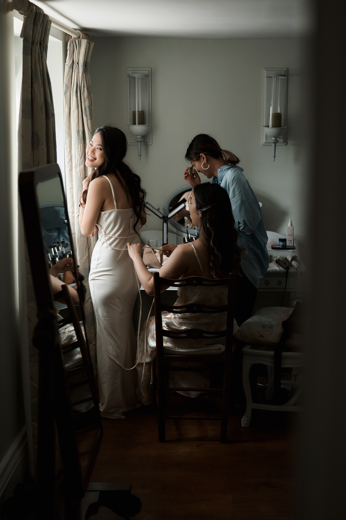 A bride and her friends are preparing in a room.