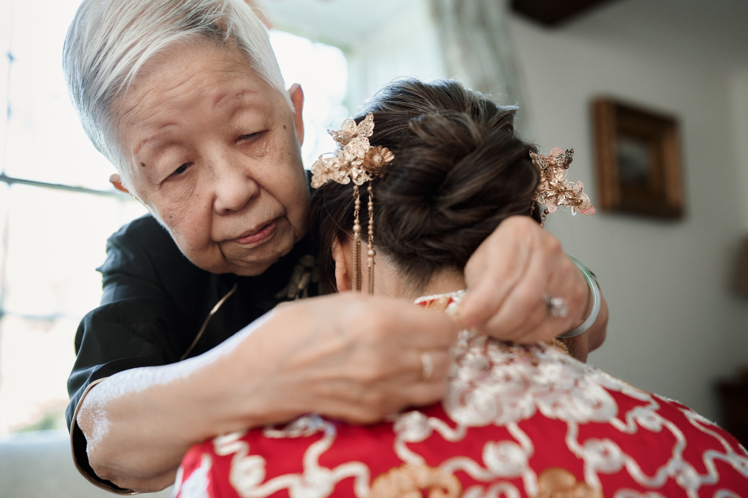 An Asian lady is wearing her grandma's traditional Japanese dress.