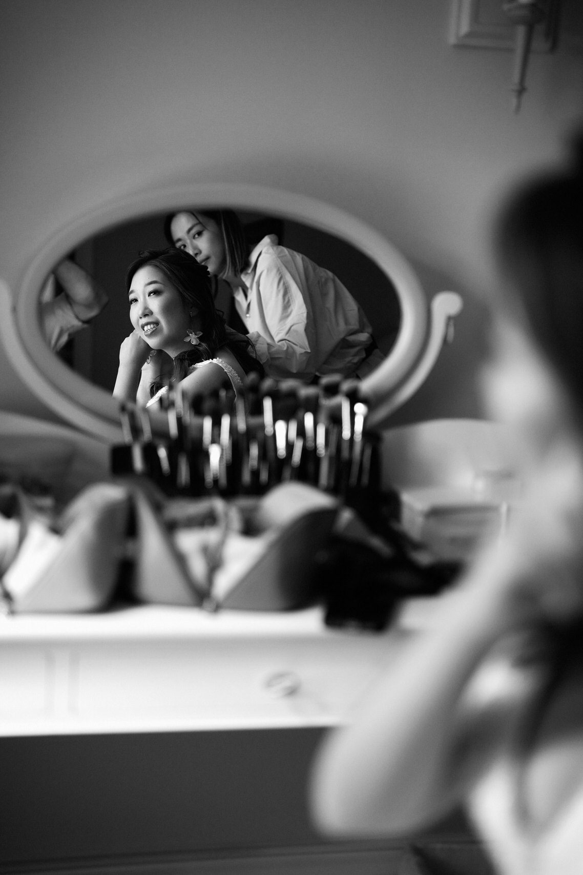 A bride preparing herself in front of a mirror.
