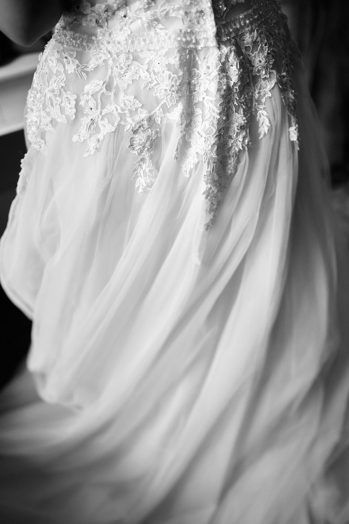 A black and white picture of a bride's wedding gown.