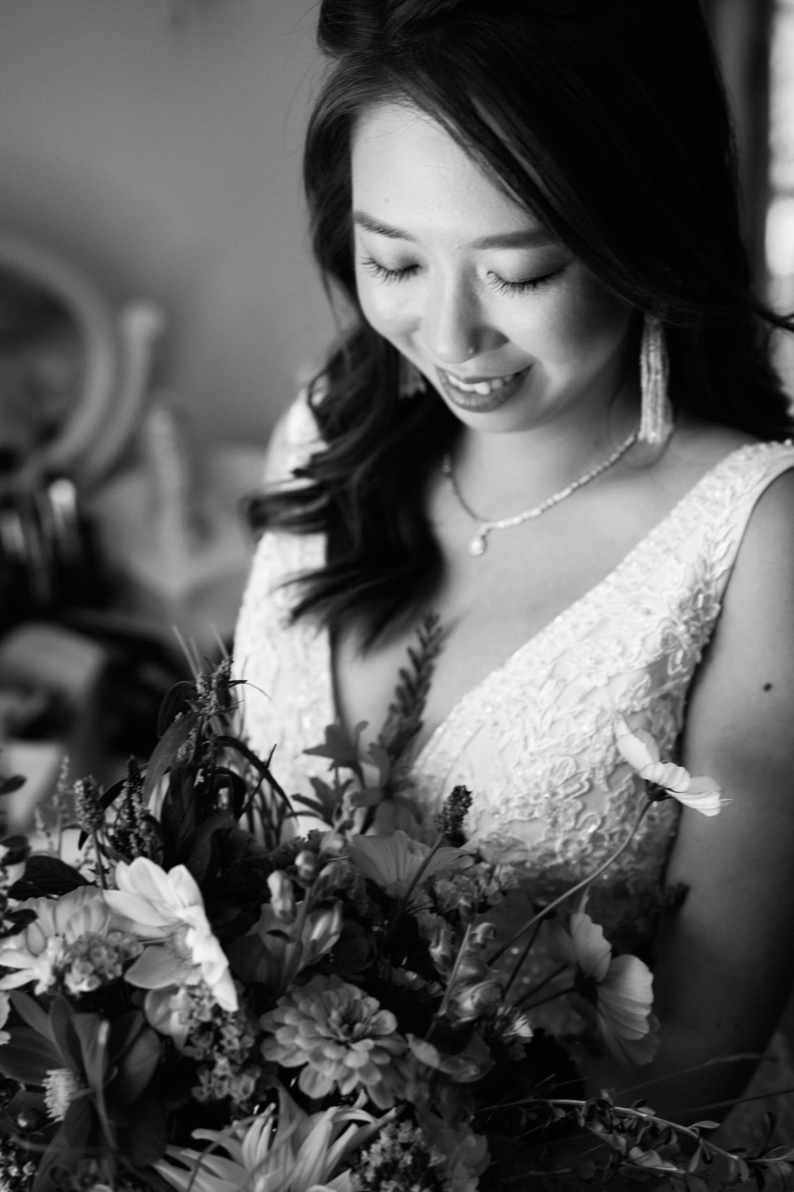 A black and white picture of a bride with her flower arrangement.