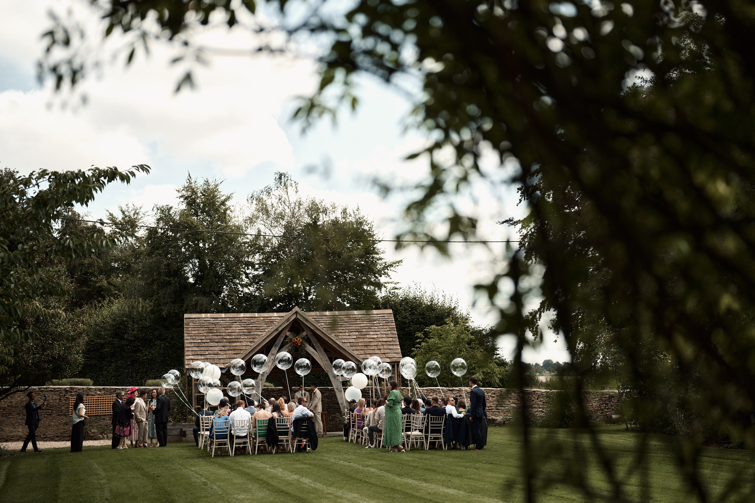 A wedding ceremony on the lawn with balloons.
