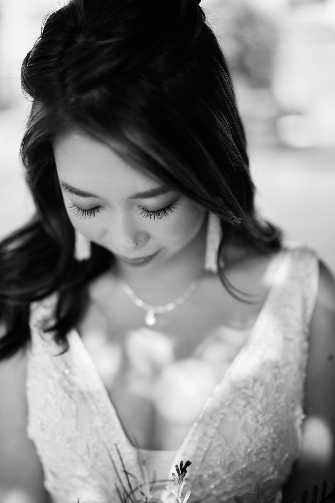 A black and white picture of a bride with flowers in her hands.