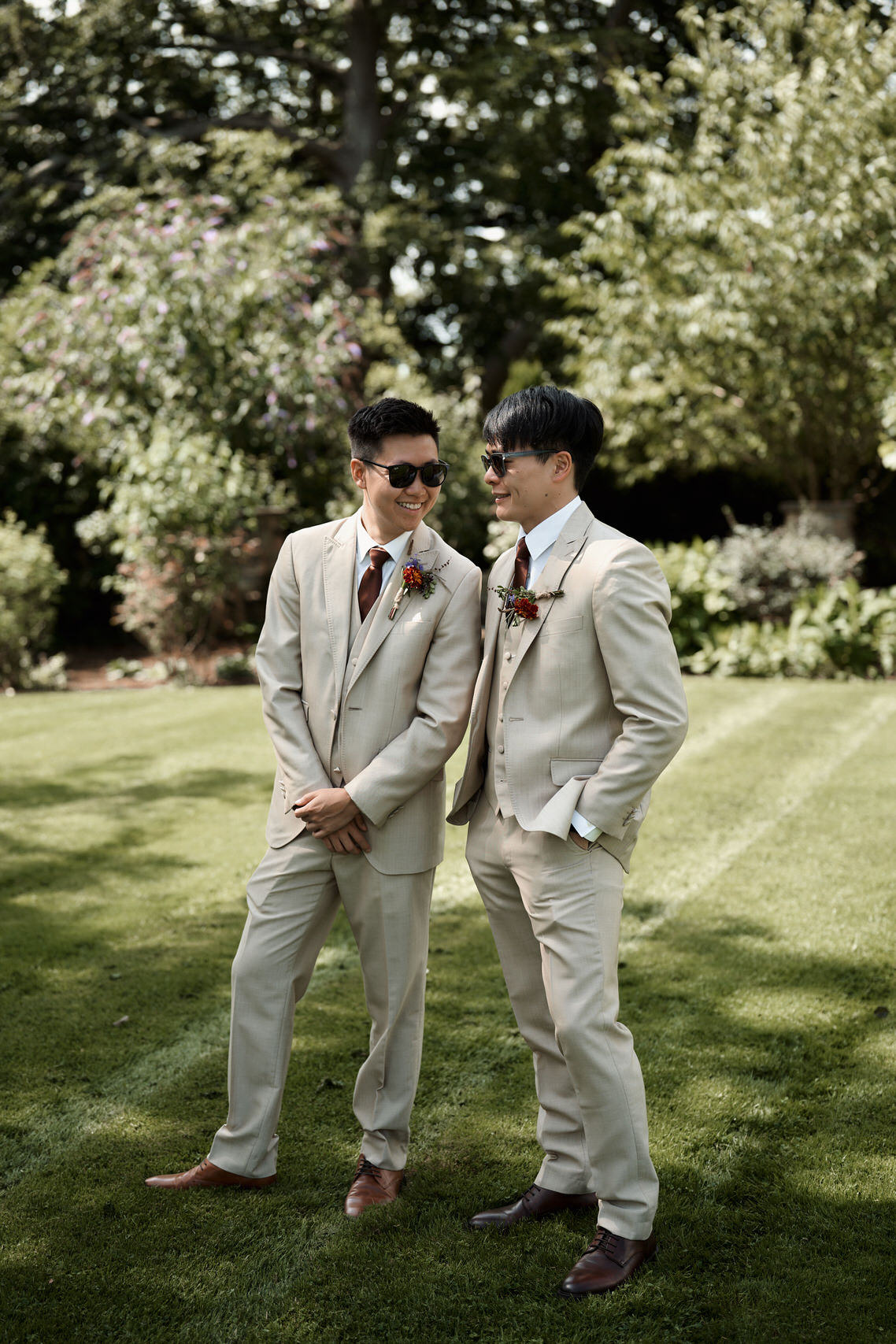Two guys in tan suits are standing on the lawn.