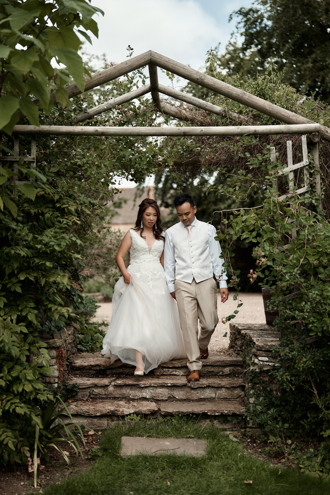 A couple getting married strolling down a garden path.