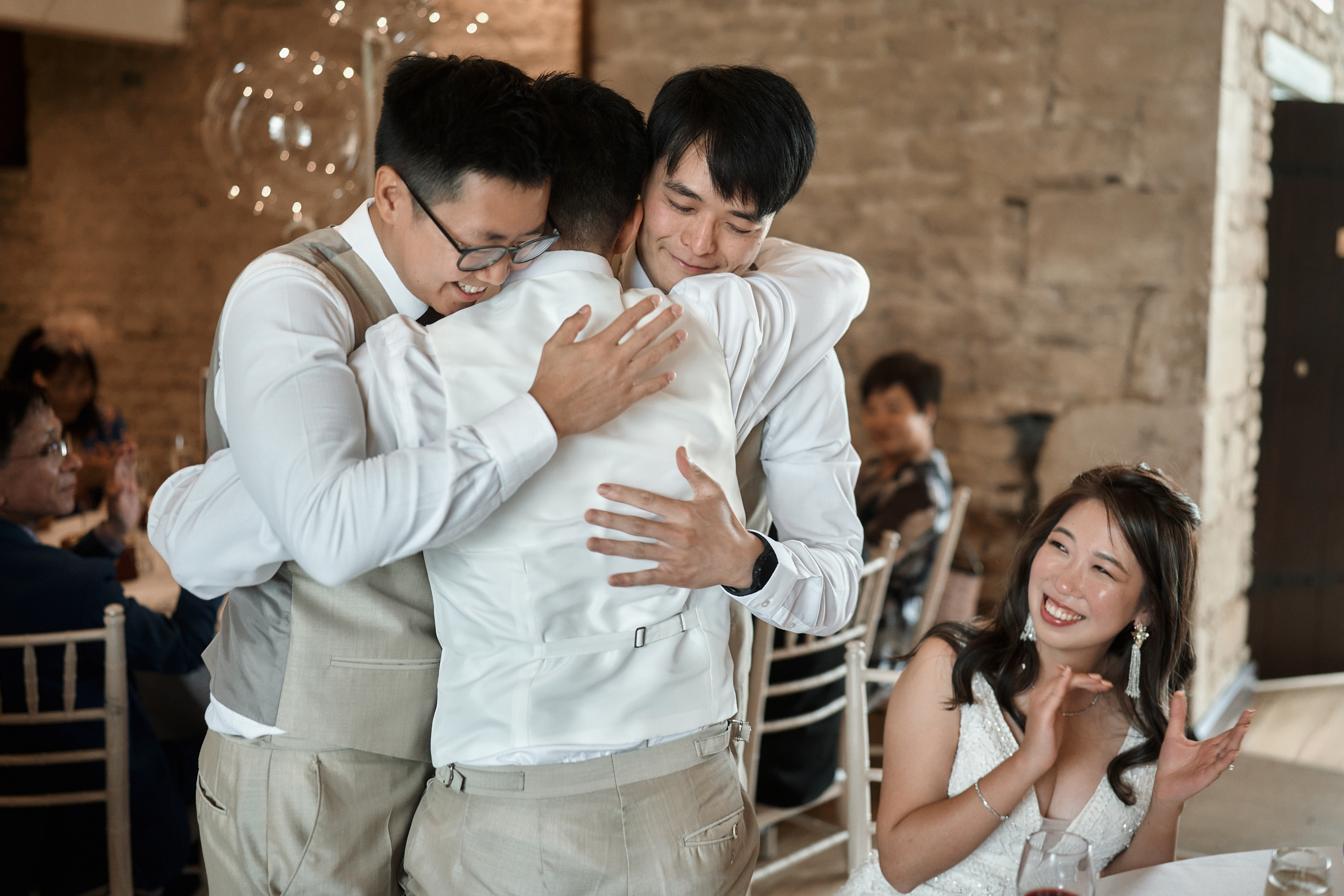 Two guys giving each other a hug at a wedding party.