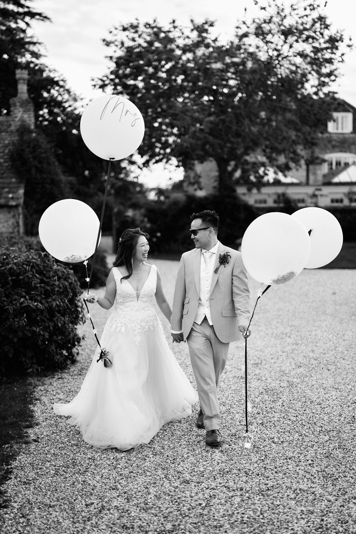 Picture of a bride and groom holding balloons in black and white.