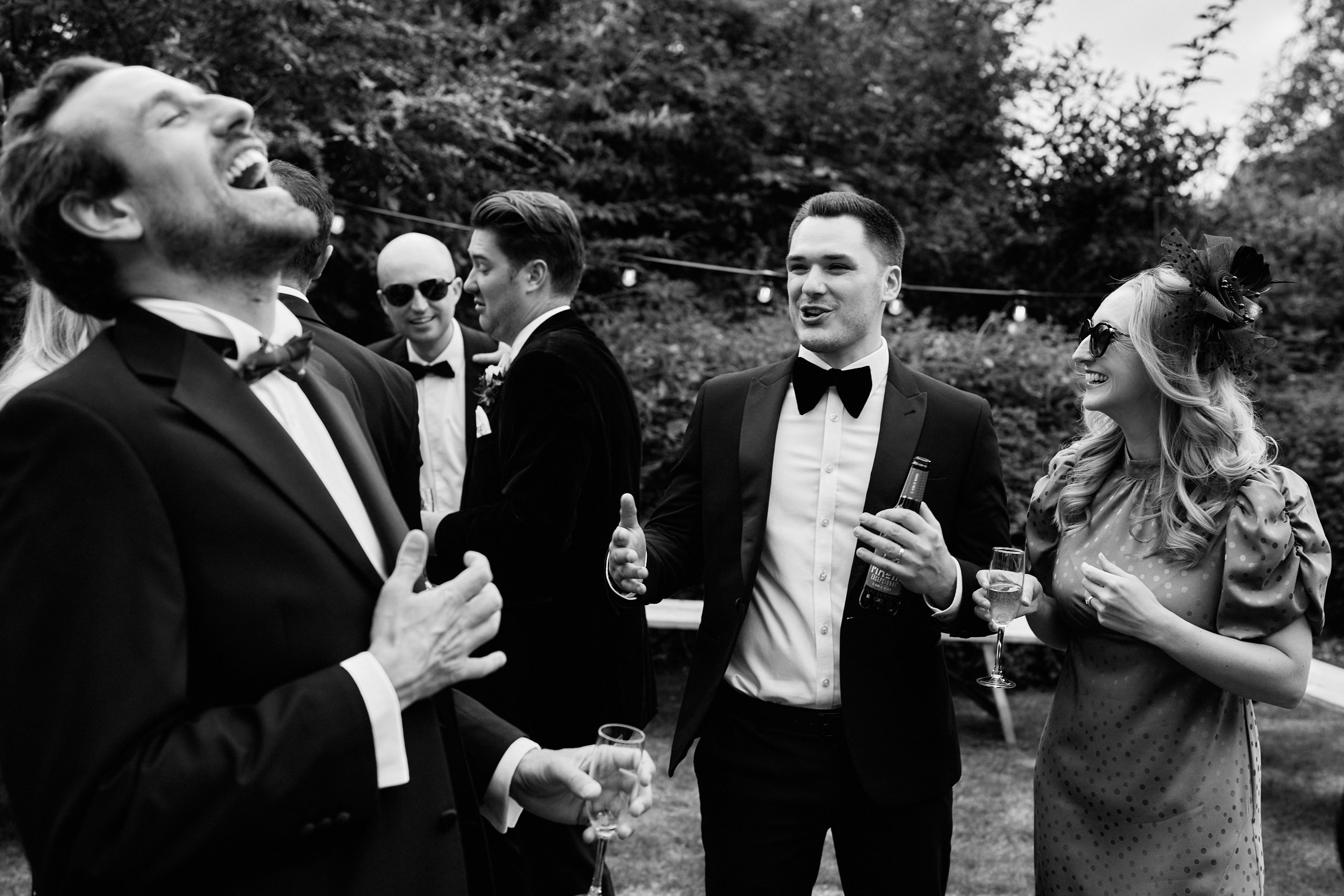 A black and white picture showing a bunch of people having a good laugh.