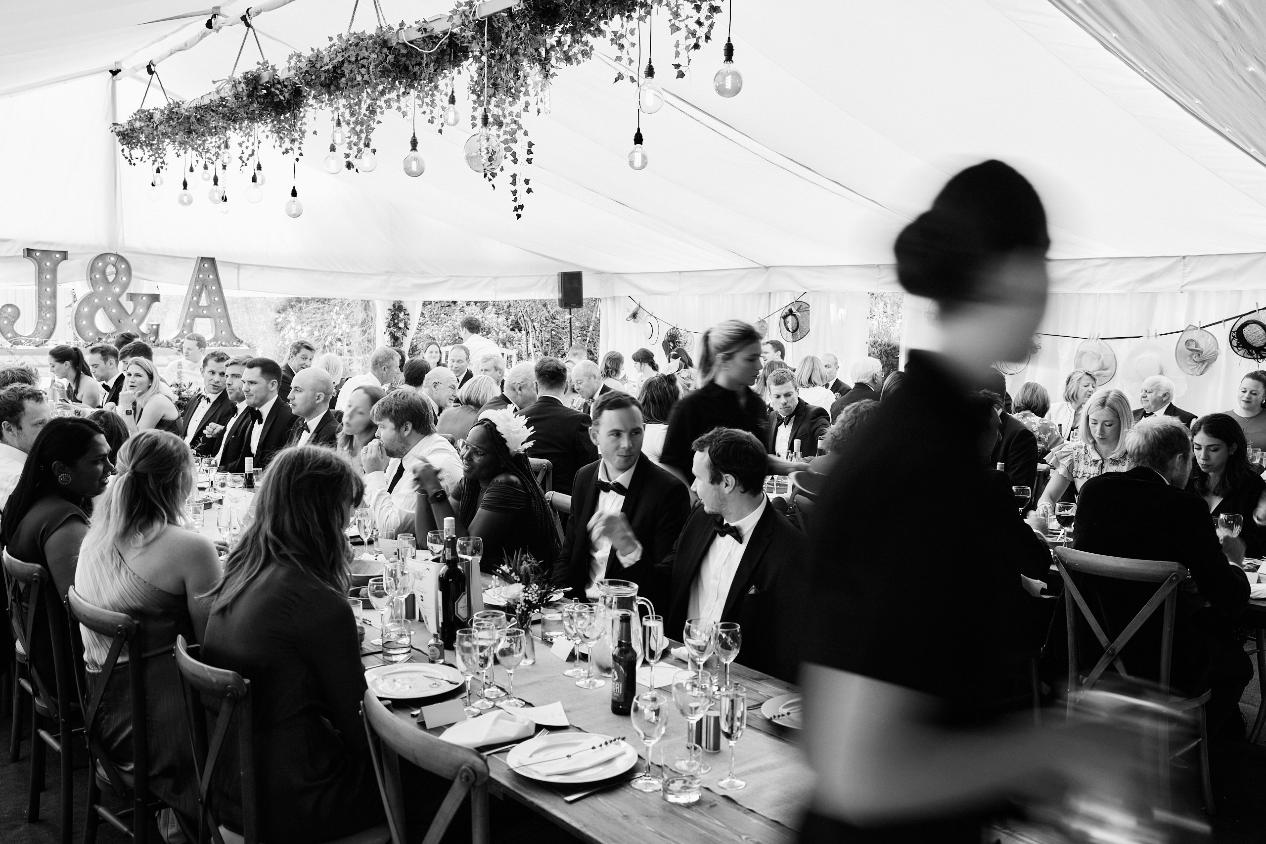 A picture in black and white showing a wedding party in a tent.