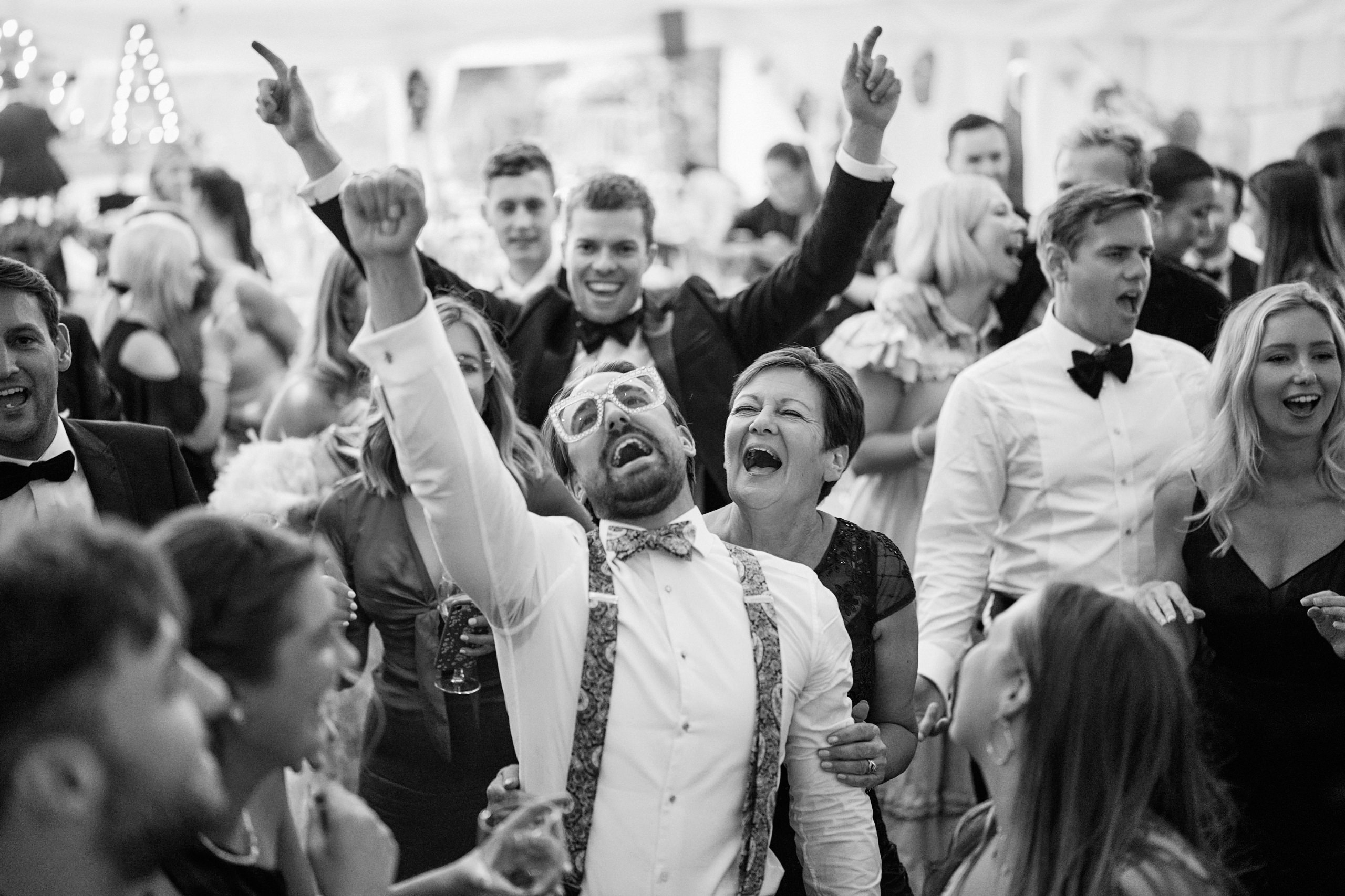 A picture in black and white of some folks dancing at a wedding.