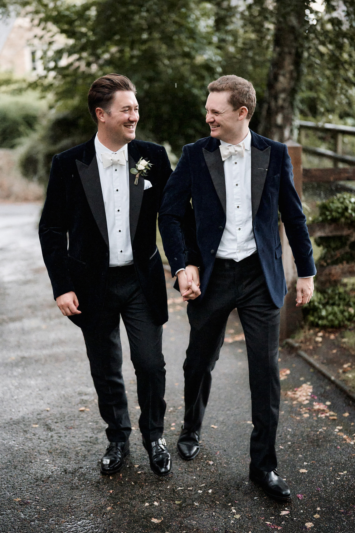 Two guys in suits are strolling down a path.
