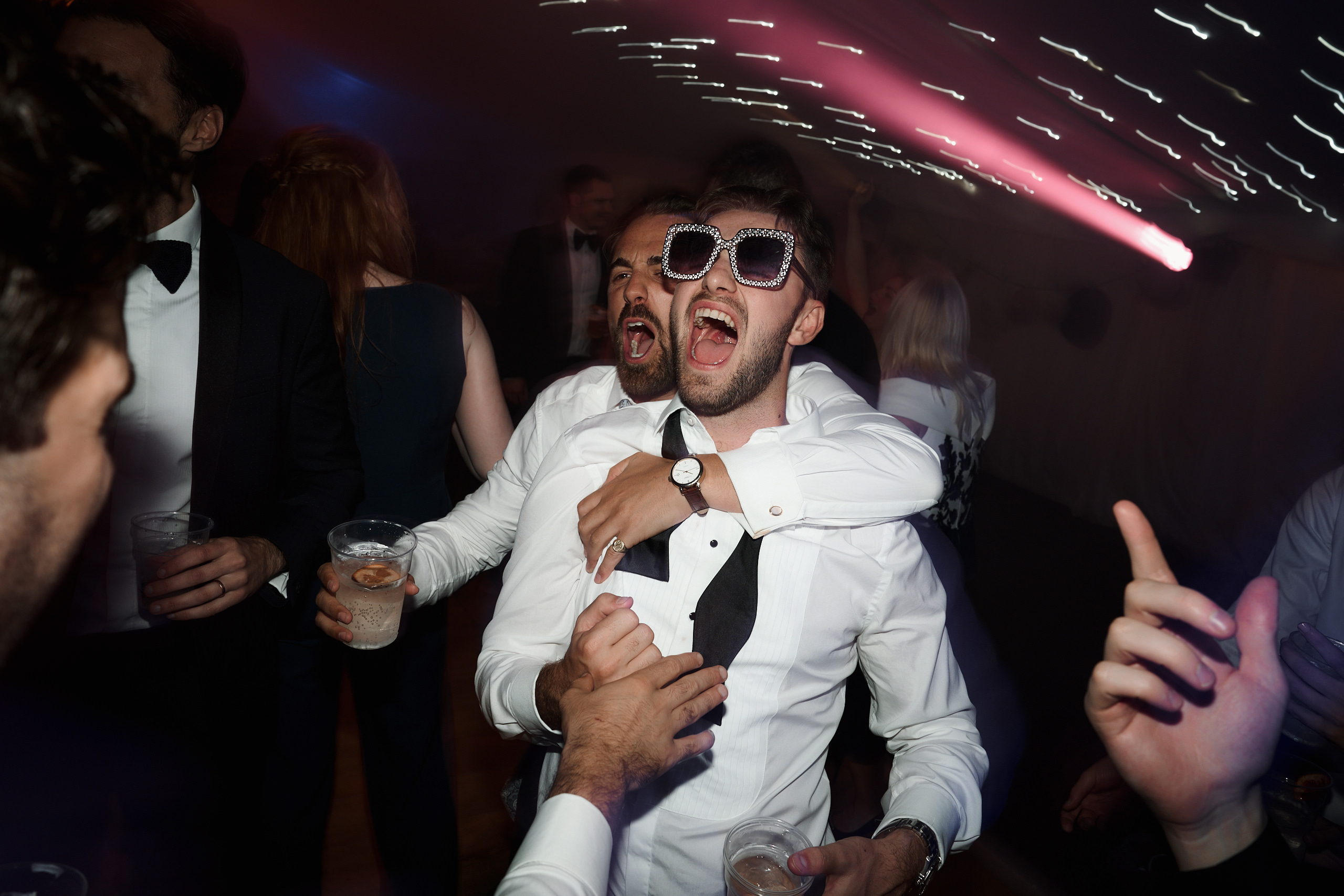 A guy with shades is enjoying himself at a party.