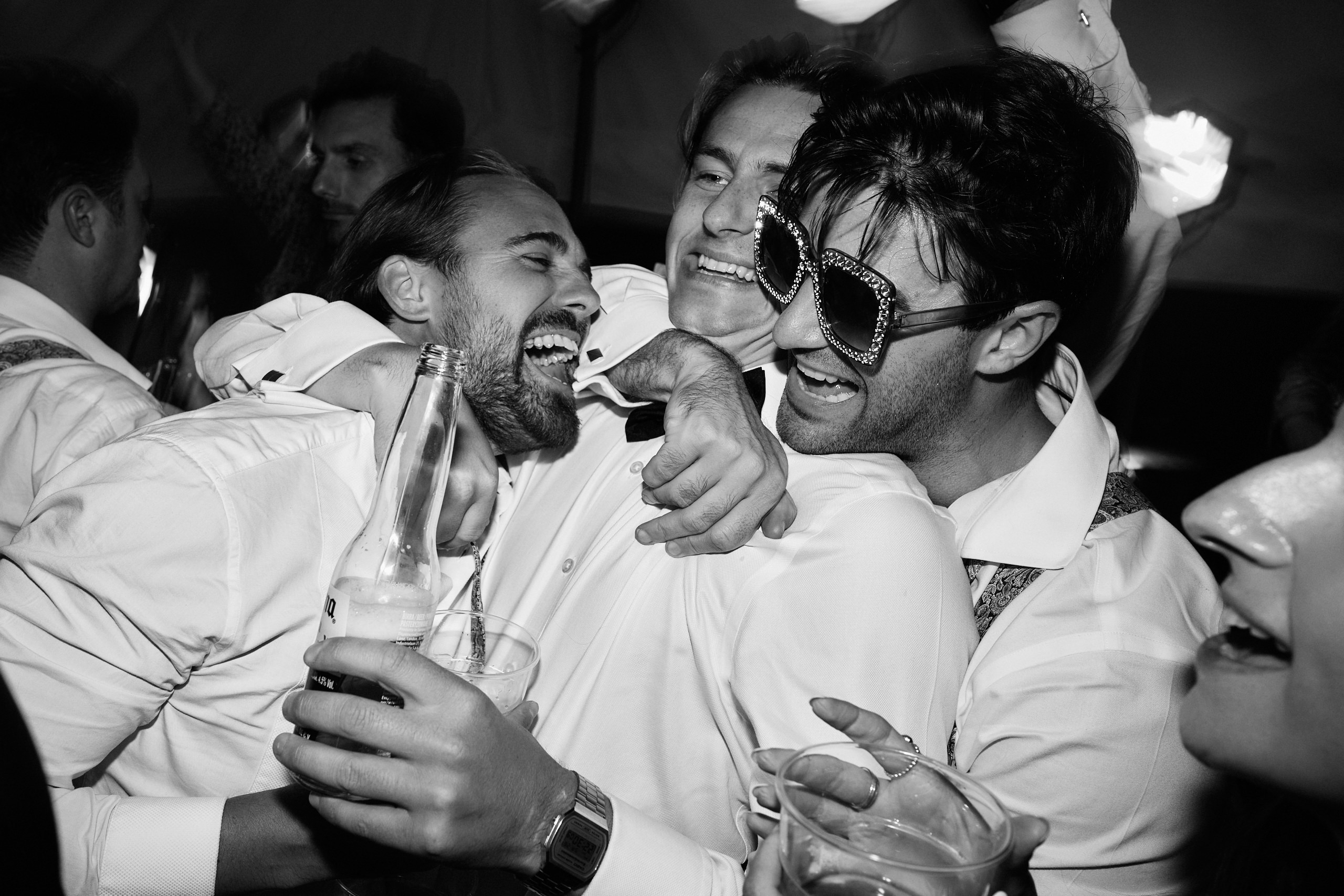 A picture in black and white showing a bunch of guys at a party.