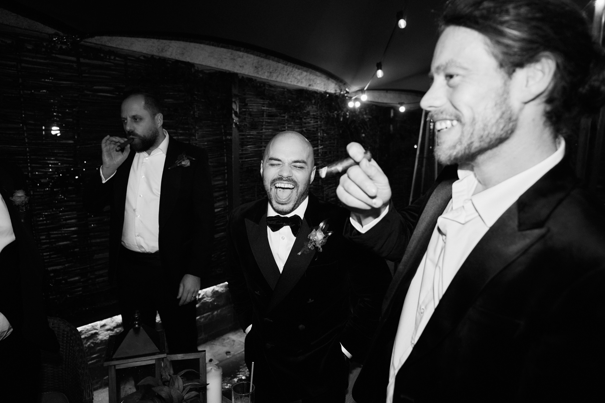 A picture in black and white of guys in suits laughing.