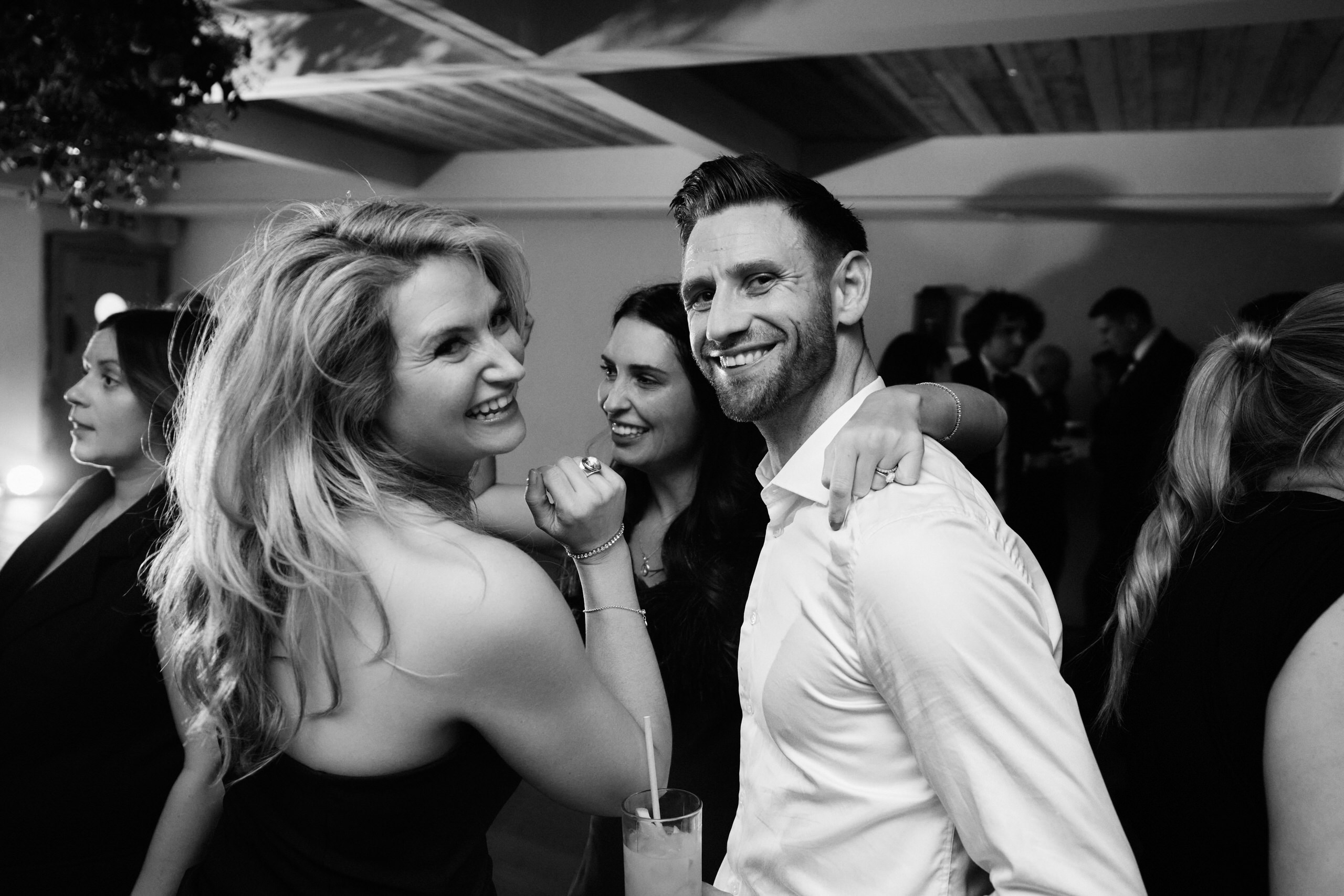 A black and white picture of a bunch of folks at a party.