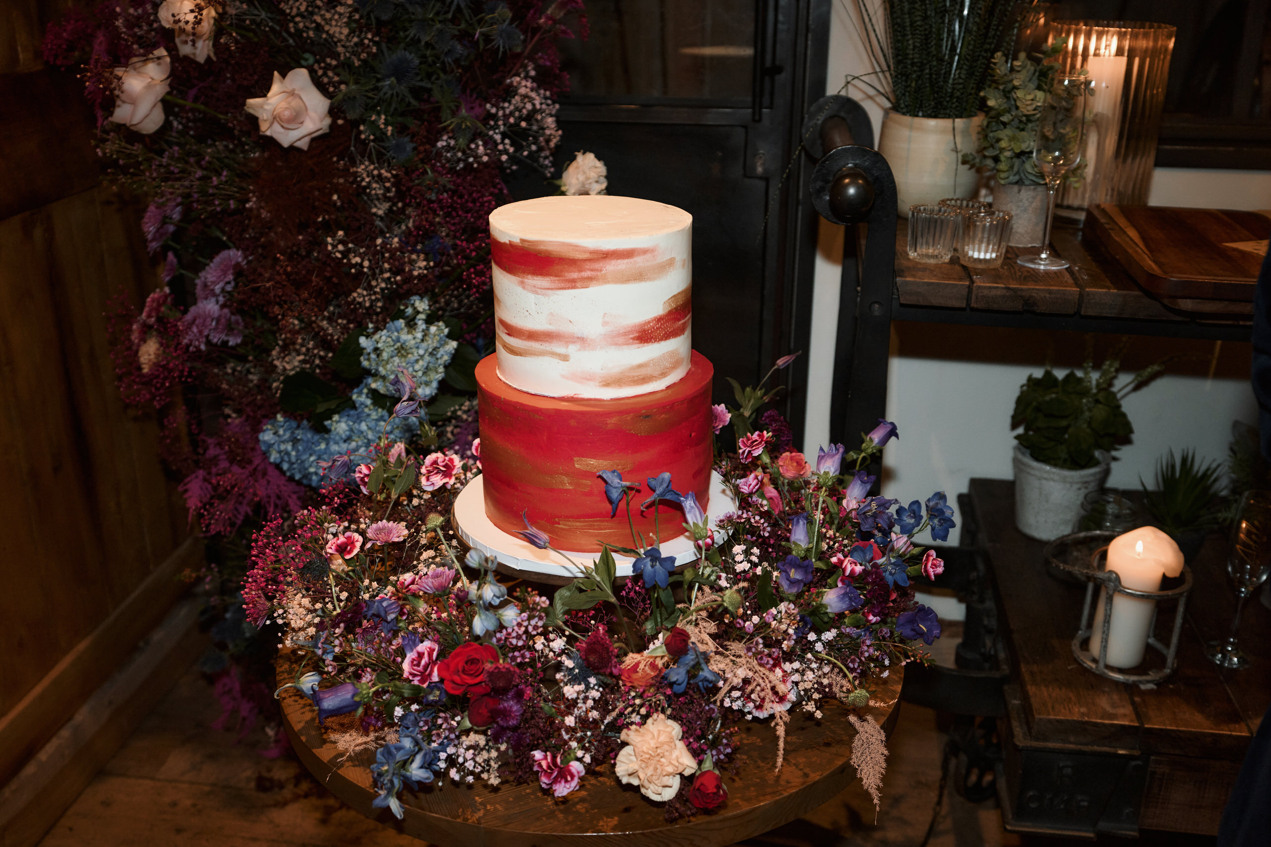A wedding cake sitting on a wood table.