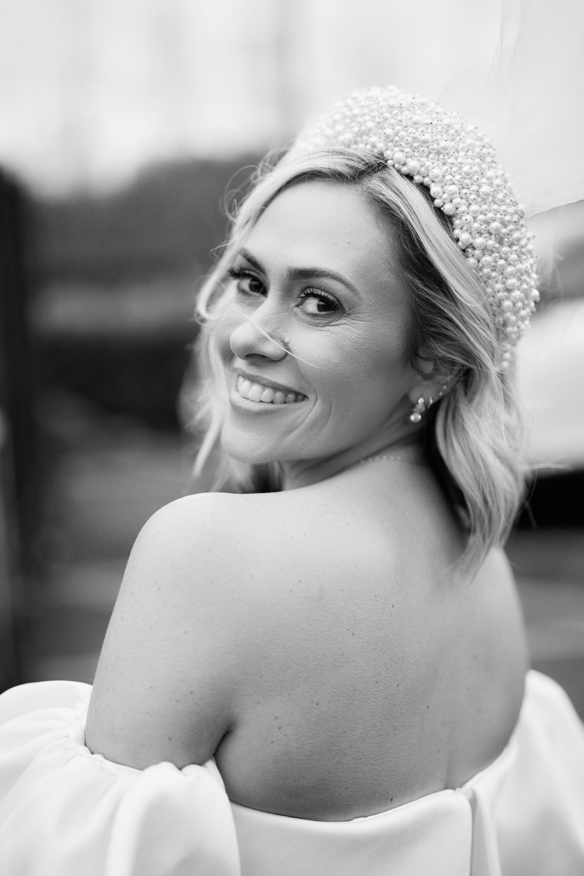 A picture in black and white of a bride wearing a white dress.