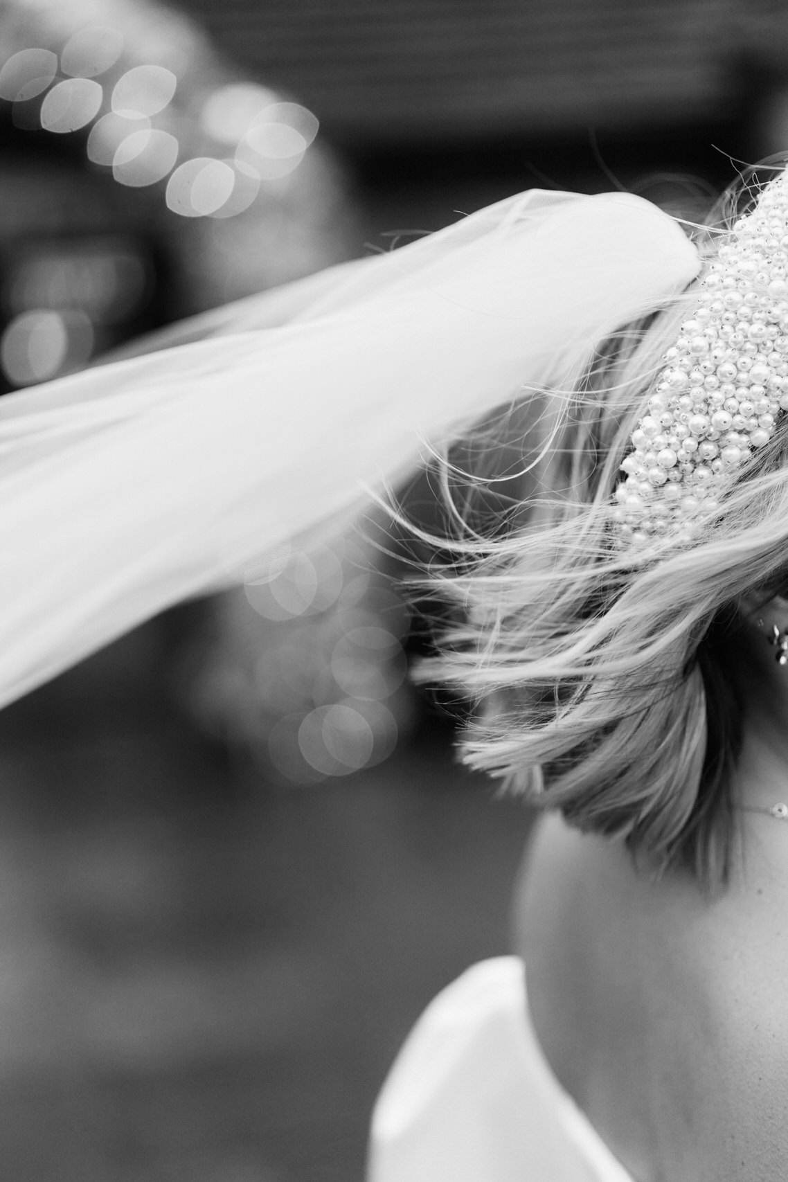 A bride's veil is fluttering in the wind.