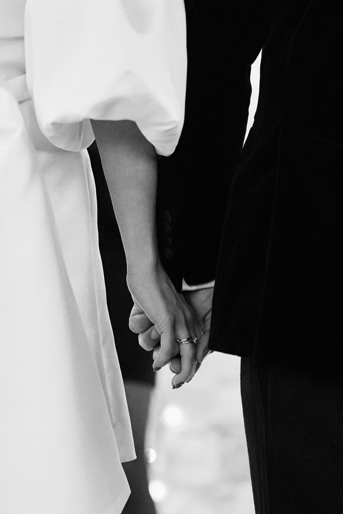 A picture in black and white showing a pair holding hands.