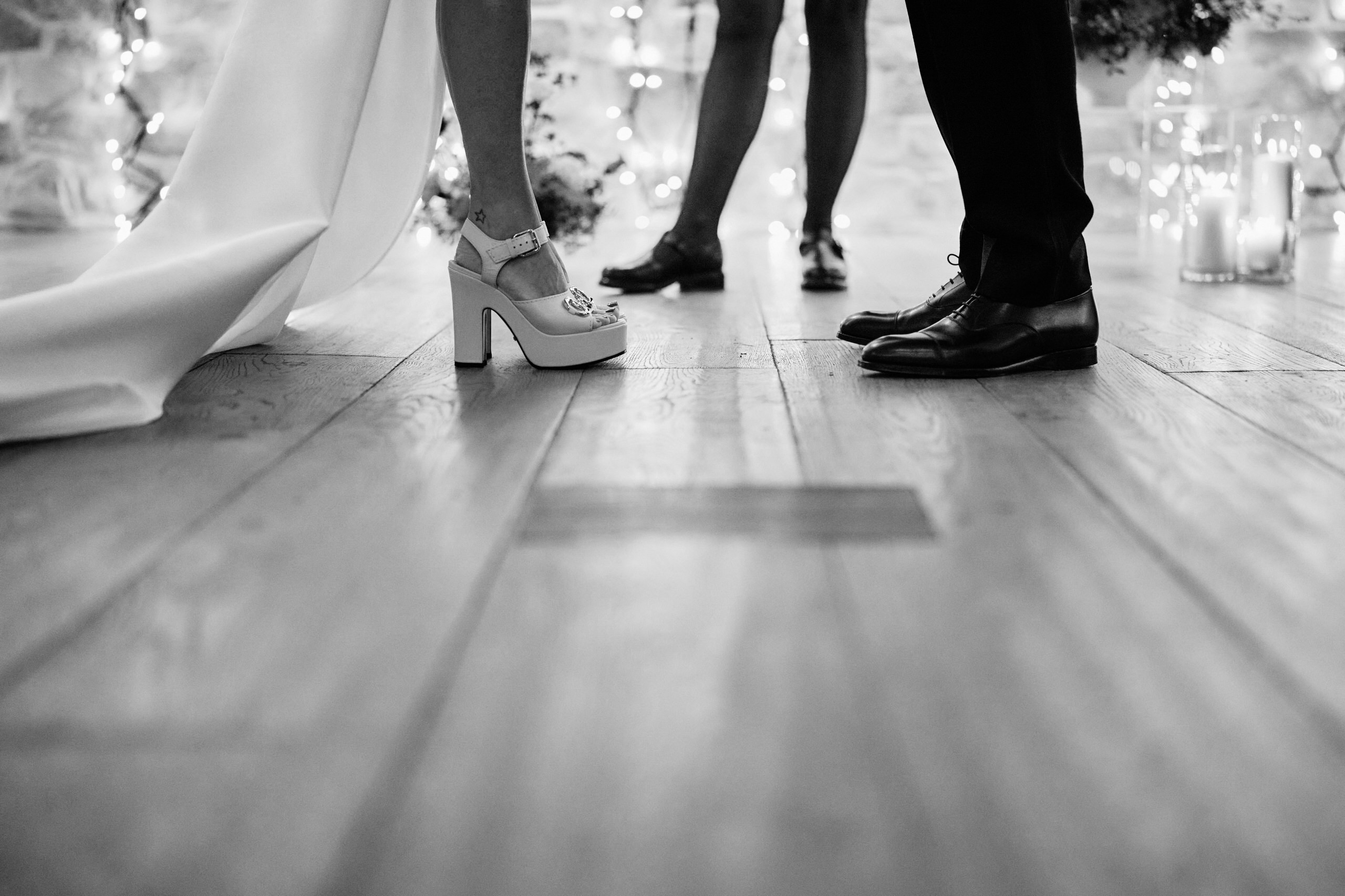 A man and woman getting married, standing on a wood floor.