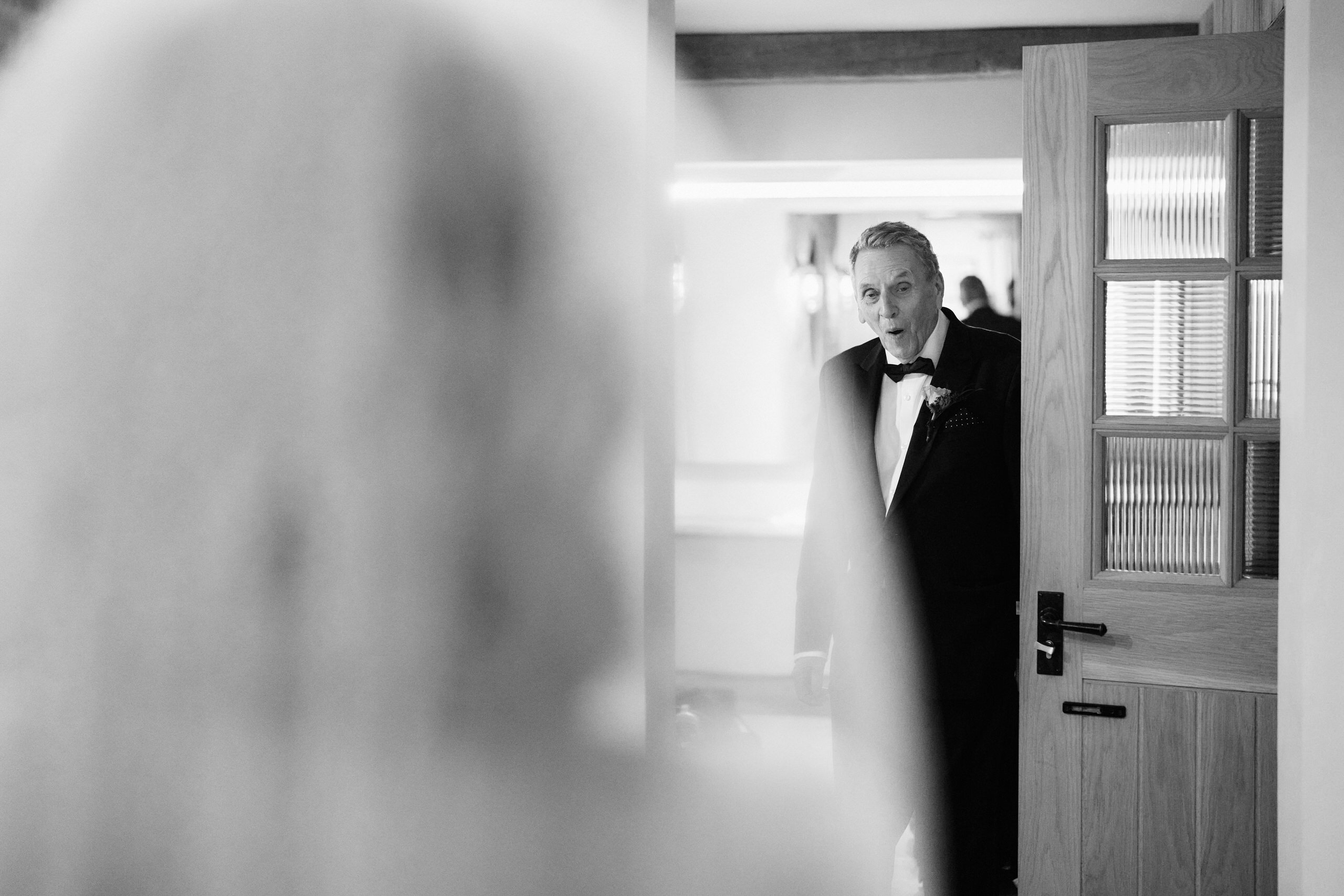 A black and white picture showing a bride and her dad looking at each other.