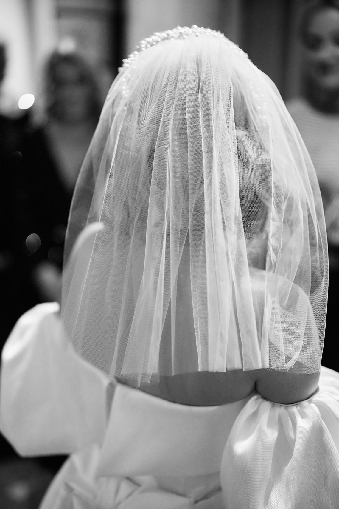 A woman dressed in a wedding gown and a veil.